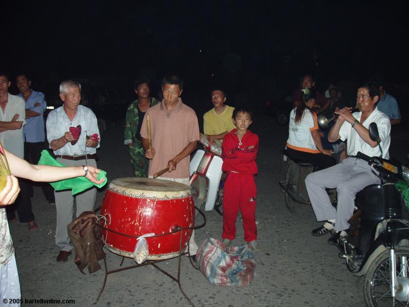 Evening musicians play in a square near the train station in Baihe, Jilin, China