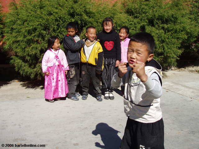 Children, led by an aspiring Jackie Chen, pose for the camera near the Three Pagodas in Dali, Yunnan, China