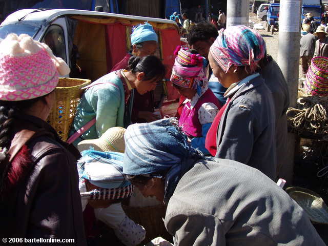 Women in colorful minority costumes at the Youshuo market in Yunnan province, China