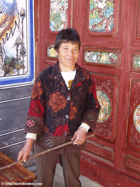 Woman cleans colorful woodwork at the Zhonghe Temple in the Cangshan mountains above Dali, Yunnan, China