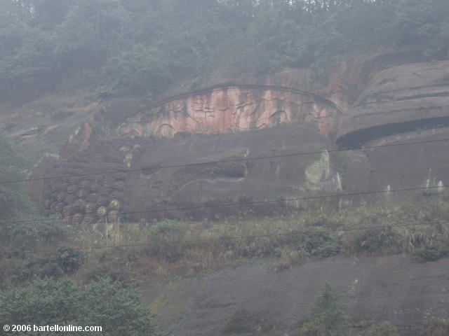 View through haze of the head of a large reclining Buddha sculpture in the Leshan Giant Buddha scenic area