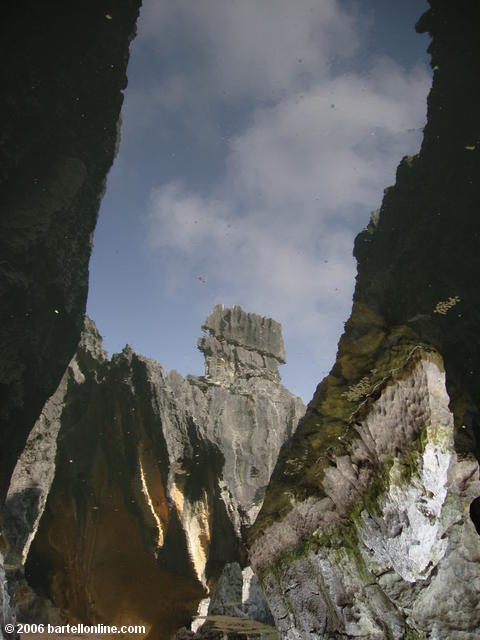 Sky and limestone karsts reflected in the Sword Pool at the Stone Forest near Kunming, Yunnan, China