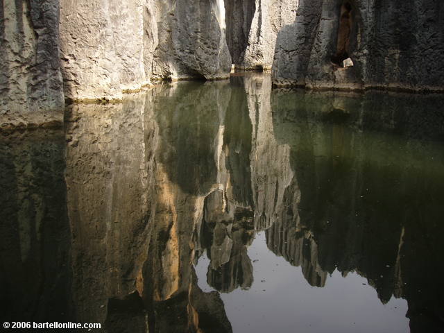 Sky and limestone karsts reflected in the Sword Pool at the Stone Forest near Kunming, Yunnan, China