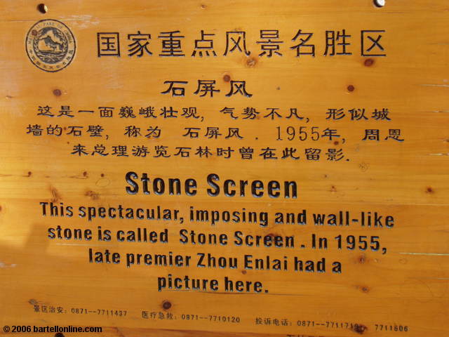 Tourists pose in costumes in from of the "Stone Screen" at the Stone Forest near Kunming, Yunnan, China