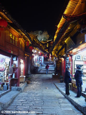 Night view of souvenir shops lining a cobblestone alley in the Old Town of Lijiang, Yunnan, China