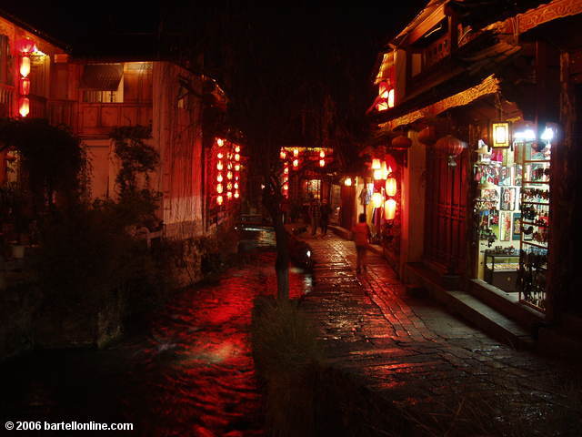 Night view of souvenir shops along a canal in the Old Town of Lijiang, Yunnan, China