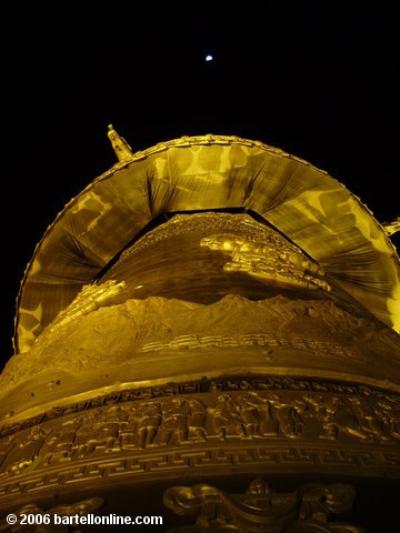The moon shines over the lighted giant Buddhist prayer wheel in Zhongdian ("Shangri-La"), Yunnan, China